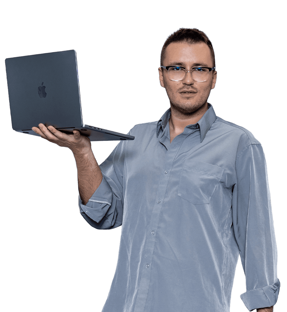 A portrait of Rafał Czuchryta looking directly into the camera with a confident expression, holding a laptop to showcase his digital expertise.